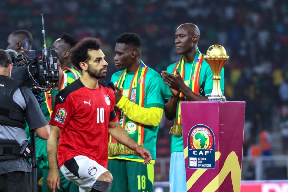 Egypt's star player, Mohamed Salah, glimps at the trophy that Senegal ran with after the final of the African Football Championships on Sunday night. 