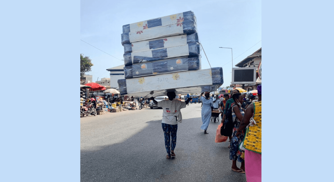 Woman carrying mattresses on her head