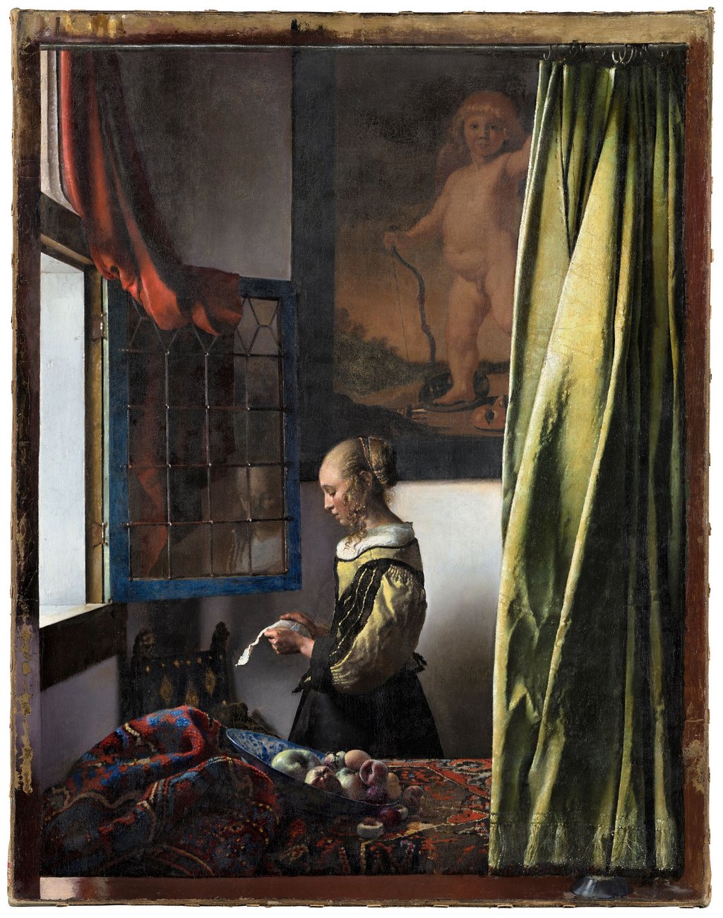 Painting of a woman reading a letter, facing and open window. Behind her is a painting of a naked angel. In front of her is a bed with colorful sheets and a bowl of fruit on top of it. In the right side of the painting is a long green curtain.